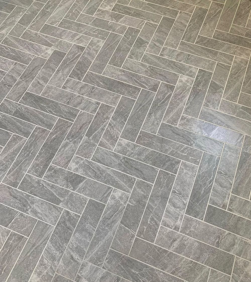 Gray stone-look tile floor laid in a herringbone pattern